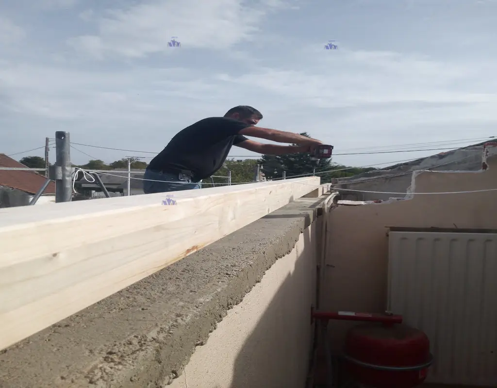 Pré-perçage de la panne sablière pour ancrage sur arase béton armé. Préparation HMLS 65 selon DTU charpente.