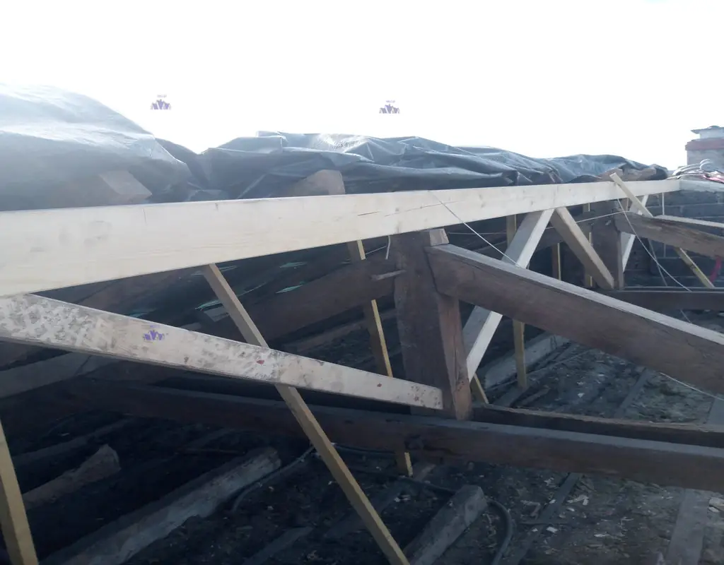 Rénovation charpente HMLS 65. Pose de contrefiches sur ferme pour renfort de faîtage. Sécurité contre le dévers et soutien vertical.