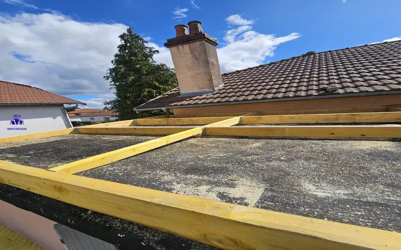 Pose du bac acier en cours sur toit-terrasse ; structure en bastaings et chevrons apparente – HMLS 65.